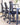 Three black mesh ergonomic office chairs with adjustable heights and casters, arranged around a modern desk in a bright office setting.